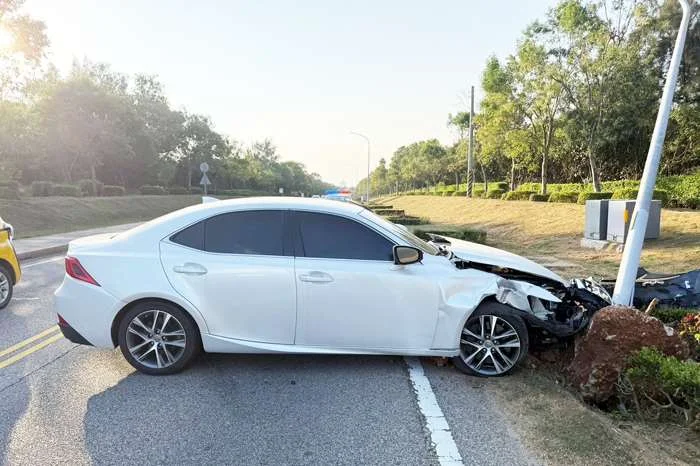 金寧鄉桃園路驚傳自撞!轎車疑因逆光失控撞歪路燈桿 2人受傷就醫