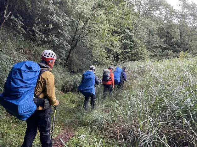 獨攀雪山西稜摔傷!苗栗消防跨夜救援,雨中馳援護送山友下山